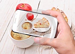 Hands taking photo apple cake with smartphone