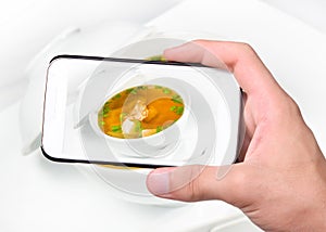 Hands taking photo soup with fungus and shrimp with smartphone