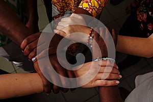 Hands of the team of happy group of African Latin American and European people which stay together in circle