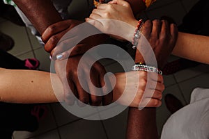 Hands of the team of happy group of African Latin American and European people which stay together in circle