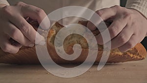 Hands tearing breaking apart fresh Baked crispy loaf of Bread, Close Up, bakery