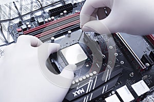 Hands of a technician assembling computer hardware parts new cpu is being mounted unto the motherboard