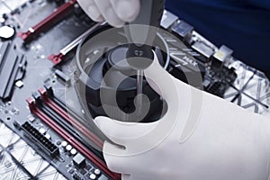 Hands of a technician assembling computer hardware parts new cpu is being mounted unto the motherboard
