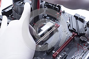 Hands of a technician assembling computer hardware parts new cpu is being mounted unto the motherboard