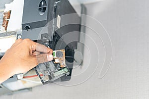 Hands of technician checking thermistor, Repairman fixing air conditioning system, Technician service for repair and maintenance photo