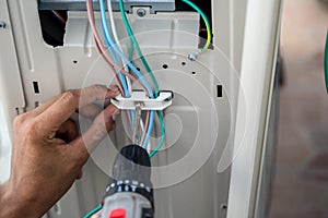 Hands of technician is using an electric motor to tighten the nut