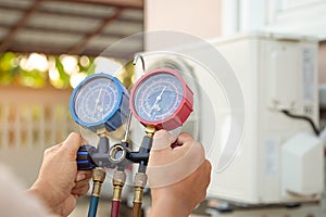 Hands of technician are using a measuring tool to check Vacuum pump evacuates air