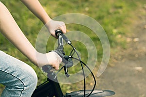 Hands of a teenager on the handlebars of a Bicycle.