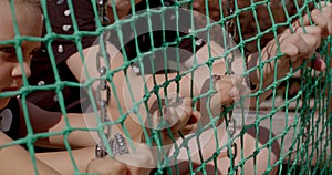 Hands teenagers pull fence mesh playground they make move, attract attention