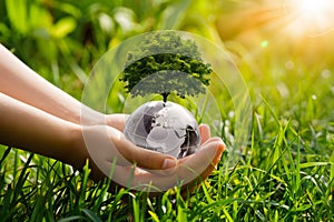 Hands tenderly holding a globe representing Earth, with blurred background