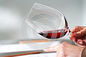 Hands testing wine density at tasting.