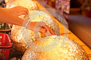 Hands of Thai people putting gold on boundary stones blessing,