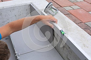 The hands of the tiler are laying the ceramic tile on the floor.