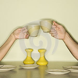 Hands toasting cups.