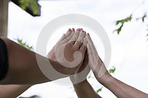 Hands together outside forming a symbol of fate teamwork bonding group of people