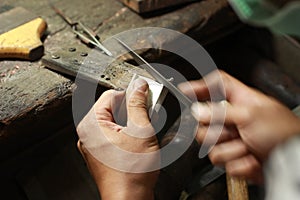 hands and tools of a professional silversmith working on a piece in his traditional workshop, Northern Thailand