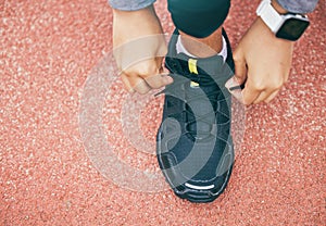 Hands, top view and woman tie shoes at running track, stadium or arena outdoors. Sports, training and black female