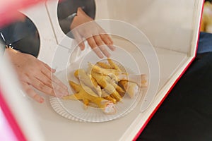hands touch Chicken feet in a box behind the glass. hoax. photo