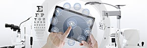 Hands touch screen of digital tablet with ophthalmologist and optometrist icons symbols, ophthalmology and optometry equipment on