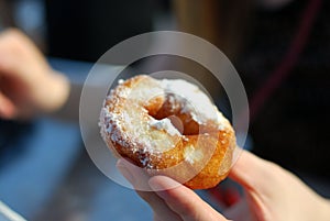 Hands touching covered with sugar donut close up.