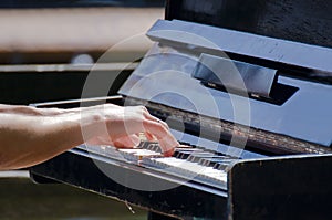 Hands touching old piano keys