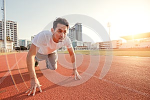 Hands on track race at sport stadium.  A man prepare for start running on track race