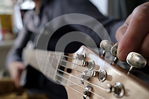 Hands tune the guitar. Repair of musical instruments.