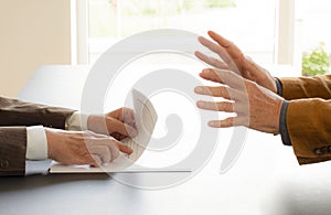 Hands from two businessmen in conversation by a desk. Negotiating business or a job interview. - Image