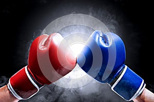 Hands of two men with blue and red boxing gloves