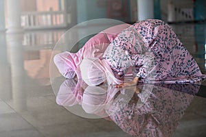 Hands of two muslim woman on the reflection floor praying in traditional clothes