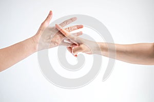 Hands of two people playing rock paper scissors; hands showing shape of scissors symbol and paper symbol; concept of business