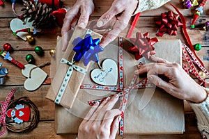 Hands of two women wrapping Christmas gifts