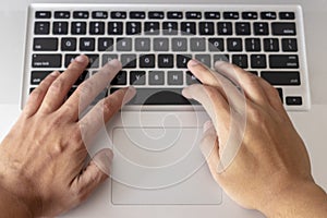 Hands typing on computer keyboard