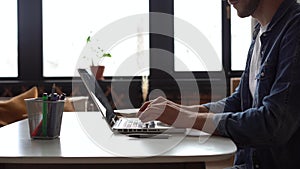 hands typing on computer keyboard, business man working on laptop pc in home office.