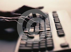 Hands typing on computer keyboard