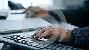 Hands typing on computer keyboard, man working on pc in office