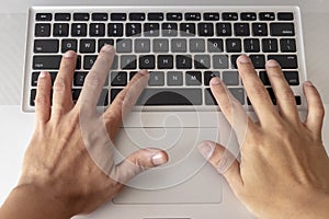 Hands typing on computer keyboard