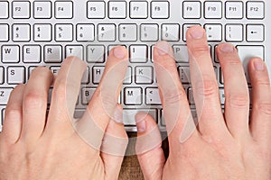 Hands typing on a computer keyboard photo