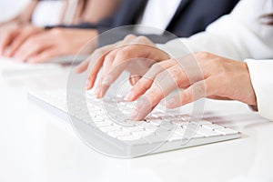 Hands typing on computer keyboards