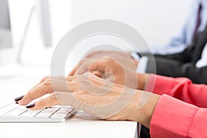 Hands typing on computer keyboards