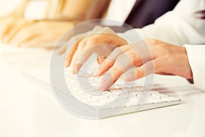 Hands typing on computer keyboards