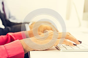 Hands typing on computer keyboards