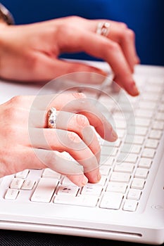 Hands typing on laptop
