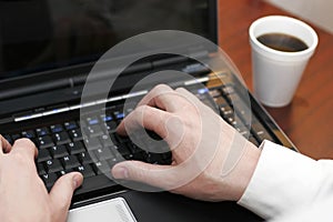 Hands typing on laptop