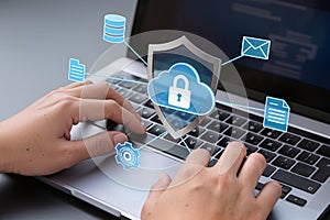 Hands typing laptop with cloud security shield interface. AI generated