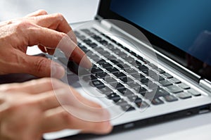 Hands typing on laptop computer