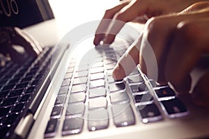 Hands typing on laptop computer