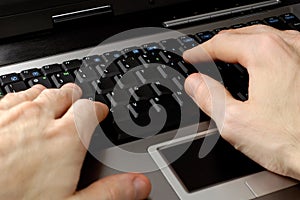 Hands typing on laptop computer keyboard communication concept