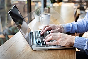 Hands typing on laptop computer keyboard, person writing email or report document in cafe with coffee and wifi internet, casual photo