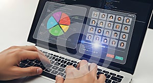 Hands typing on laptop displaying data analytics and user profiles
